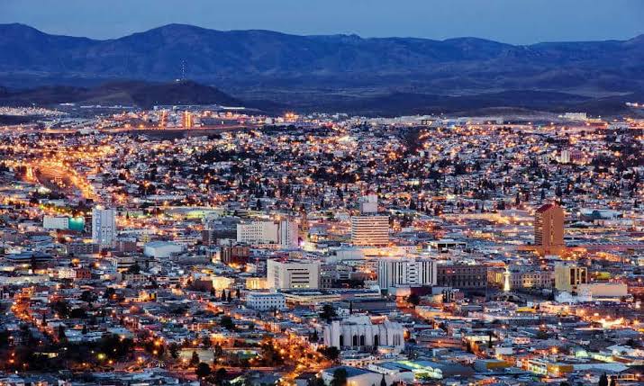 Panorámica nocturna de Ciudad Juárez con montañas al fondo